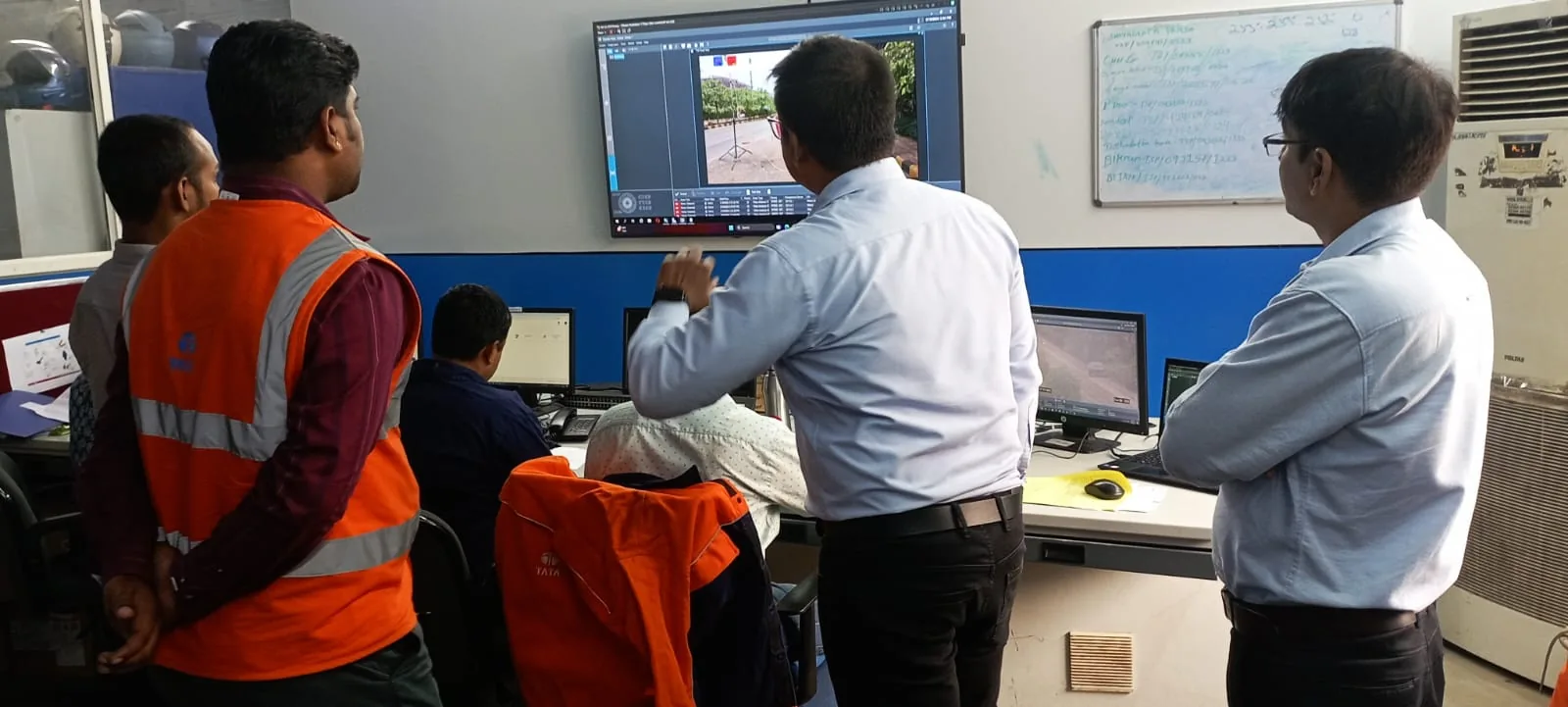 Technical team reviewing systems at monitoring workstations